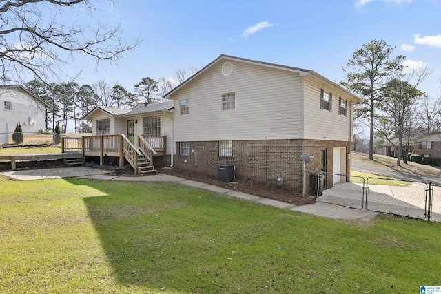 back of house featuring central AC, a wooden deck, and a lawn