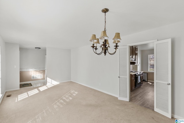 empty room with a chandelier and light colored carpet