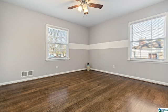 empty room with dark hardwood / wood-style flooring, ceiling fan, and a wealth of natural light