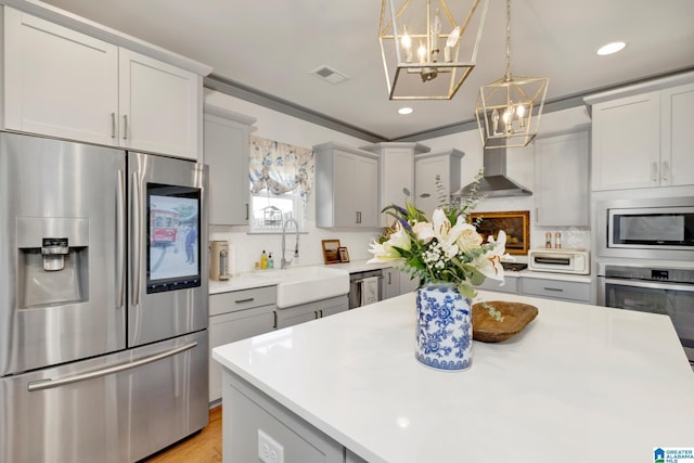 kitchen with pendant lighting, stainless steel appliances, tasteful backsplash, sink, and a notable chandelier