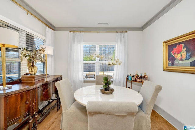 dining room featuring ornamental molding and light hardwood / wood-style flooring