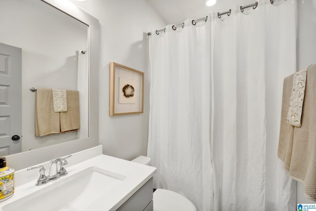 bathroom featuring toilet, a shower with shower curtain, and vanity