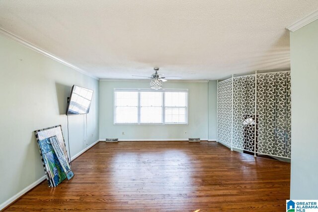 unfurnished room featuring ceiling fan, dark wood-type flooring, ornamental molding, and a textured ceiling