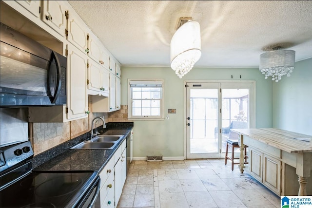 kitchen with decorative backsplash, white cabinetry, black appliances, and a notable chandelier