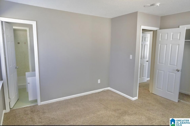 unfurnished bedroom featuring light colored carpet and a textured ceiling