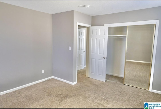 unfurnished bedroom with light carpet and a closet