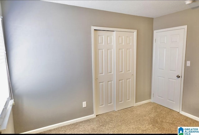 unfurnished bedroom featuring light colored carpet and a closet