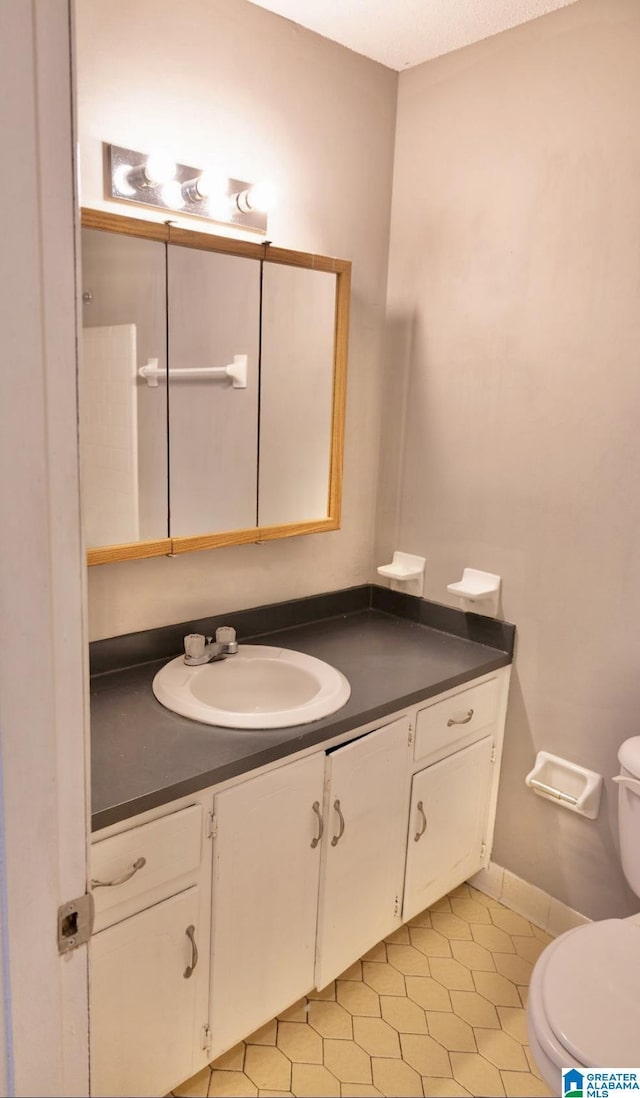 bathroom with tile patterned floors, vanity, and toilet