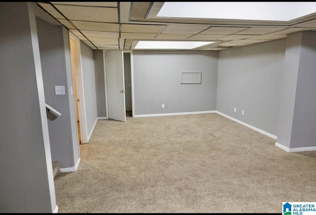 basement featuring light colored carpet and a drop ceiling