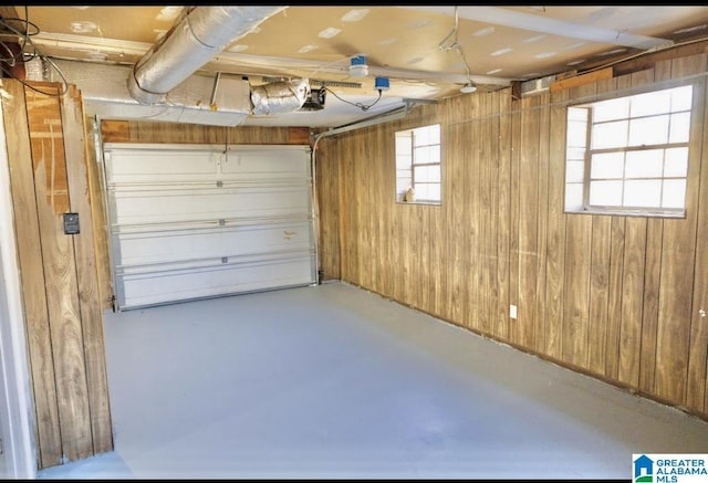 garage featuring a garage door opener and wood walls