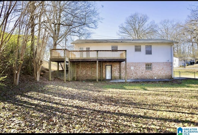 back of house featuring a wooden deck and a yard