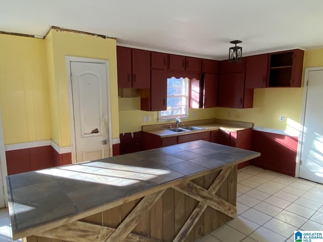 kitchen with light tile patterned floors, tile counters, and sink