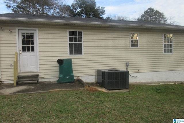 back of house featuring a lawn and central AC