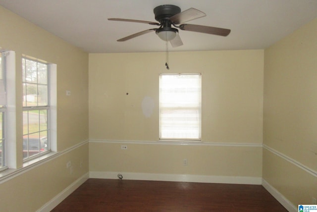 empty room with ceiling fan and dark hardwood / wood-style flooring