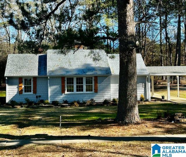 view of front of house featuring a front lawn and a carport