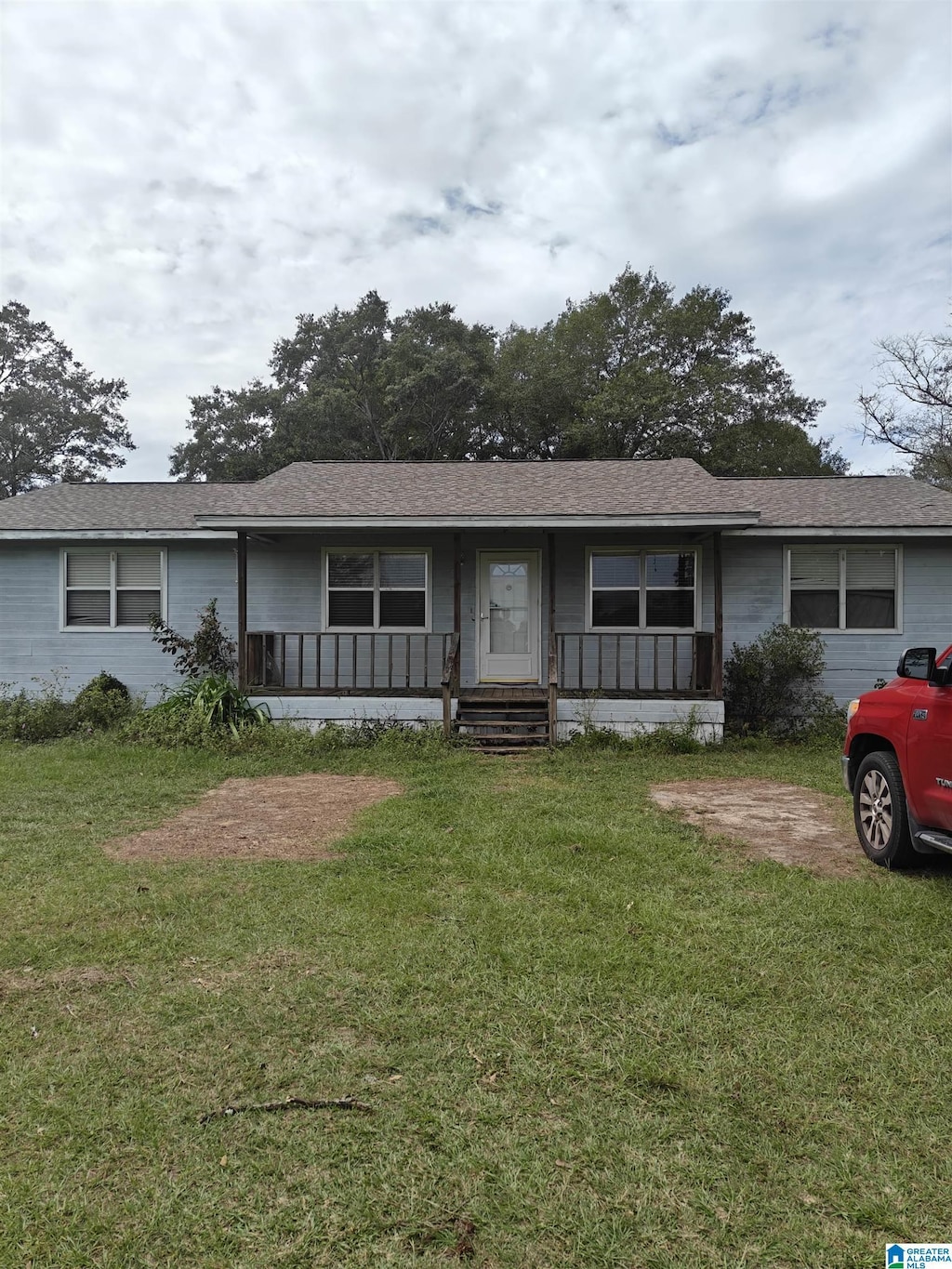 single story home featuring covered porch and a front yard