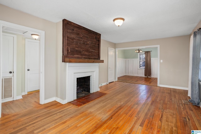 unfurnished living room with a brick fireplace and wood-type flooring