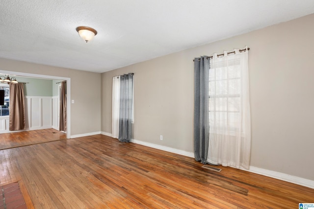 unfurnished room with a textured ceiling and hardwood / wood-style floors