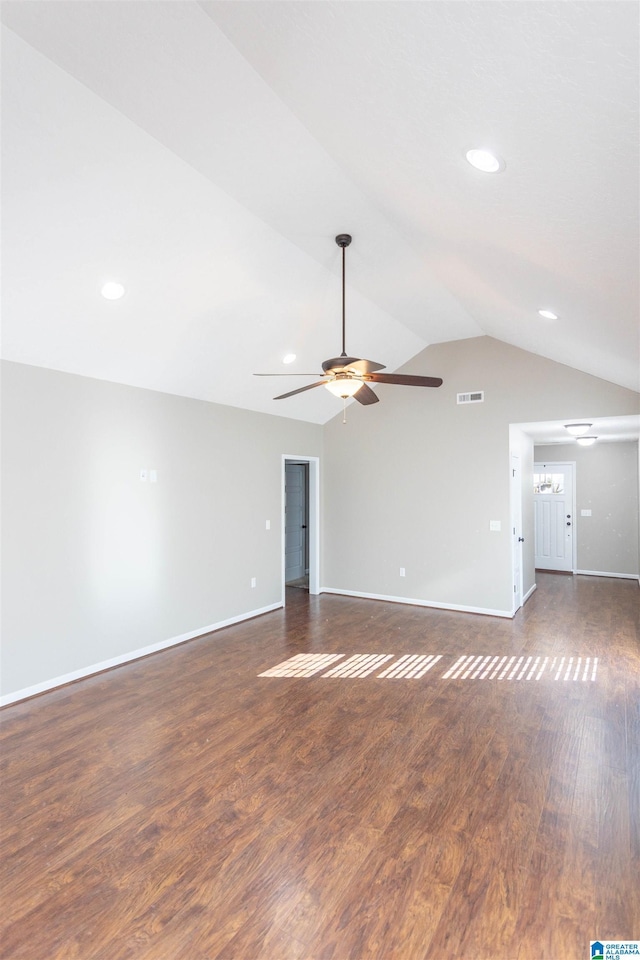 unfurnished living room with dark wood-style flooring, lofted ceiling, visible vents, a ceiling fan, and baseboards