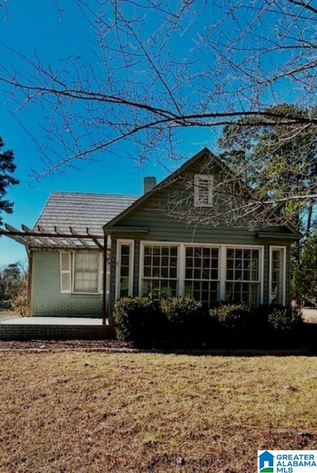 back of house featuring a lawn