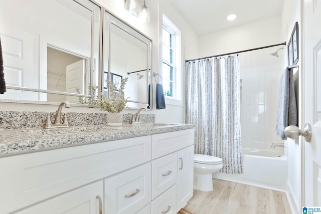 full bathroom featuring toilet, shower / bath combination with curtain, hardwood / wood-style flooring, and vanity