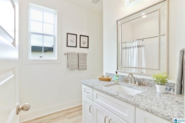 bathroom featuring walk in shower, vanity, and hardwood / wood-style flooring