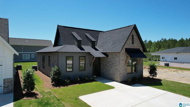 view of front of house featuring a front lawn and central AC