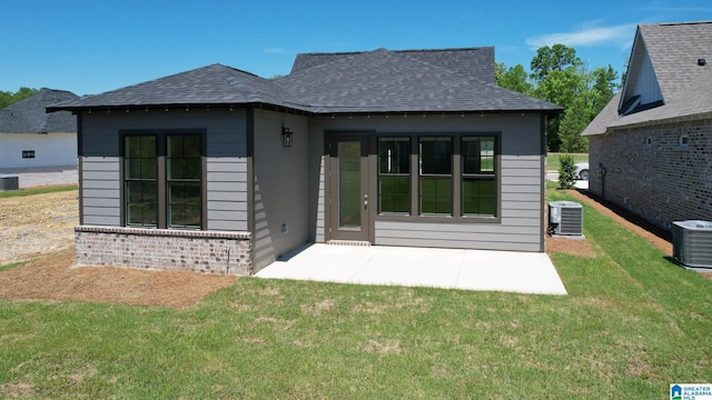 rear view of house featuring cooling unit, a yard, and a patio