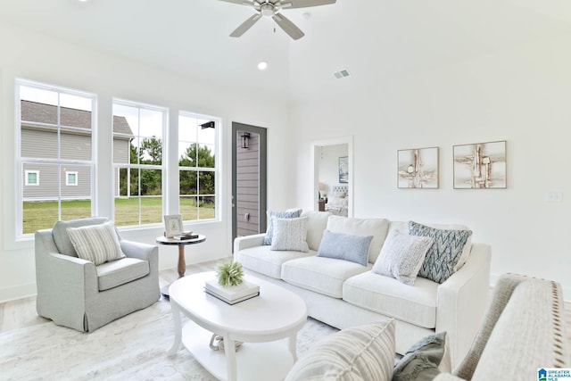 living room featuring ceiling fan and a towering ceiling