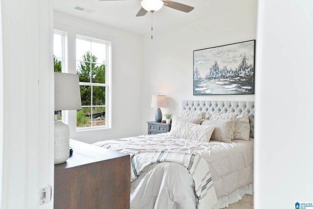 bedroom with ceiling fan, multiple windows, and carpet floors