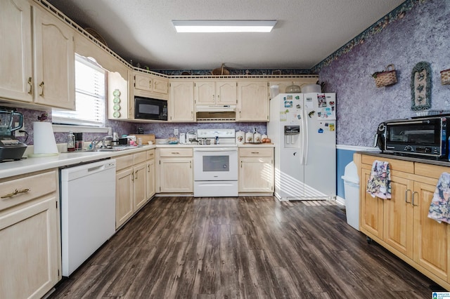 kitchen featuring dark hardwood / wood-style flooring, sink, white appliances, and a textured ceiling