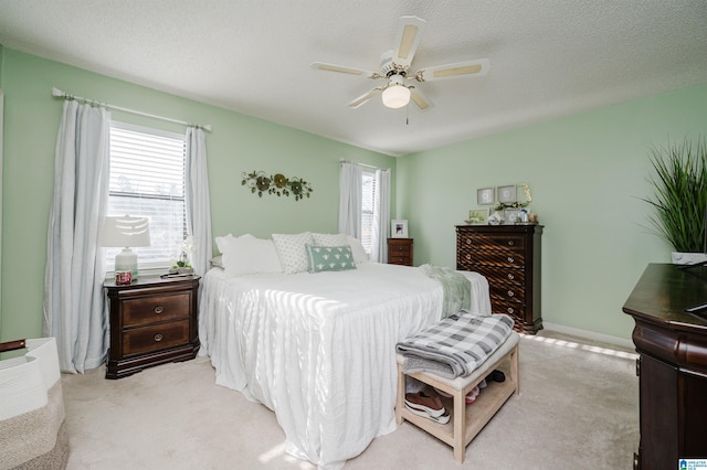 carpeted bedroom featuring ceiling fan and a textured ceiling