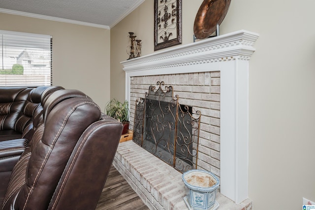 living room featuring a textured ceiling, a brick fireplace, ornamental molding, and hardwood / wood-style flooring