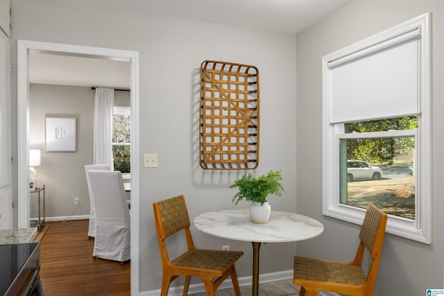 dining space with a wealth of natural light and dark hardwood / wood-style flooring