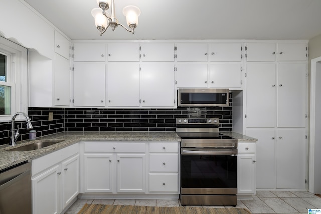 kitchen with white cabinets, backsplash, appliances with stainless steel finishes, and sink