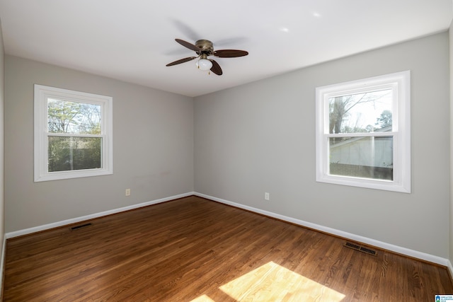 empty room with hardwood / wood-style flooring, a wealth of natural light, and ceiling fan