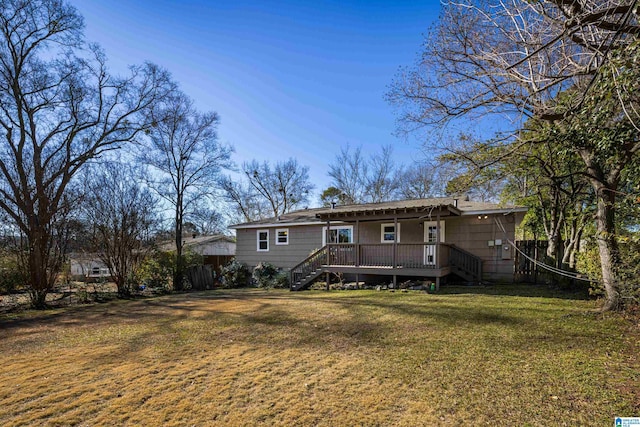 back of house featuring a lawn and a deck