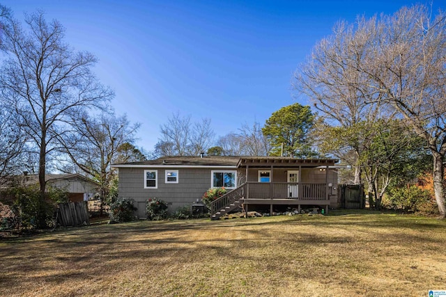 rear view of house featuring a lawn and a deck