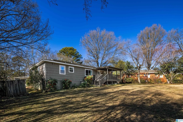 rear view of property with a deck and a lawn