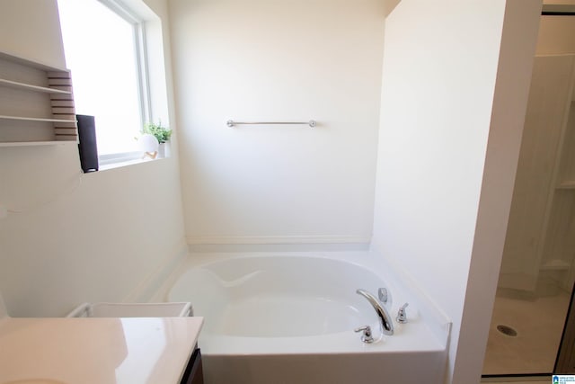 bathroom featuring vanity, plus walk in shower, and a wealth of natural light