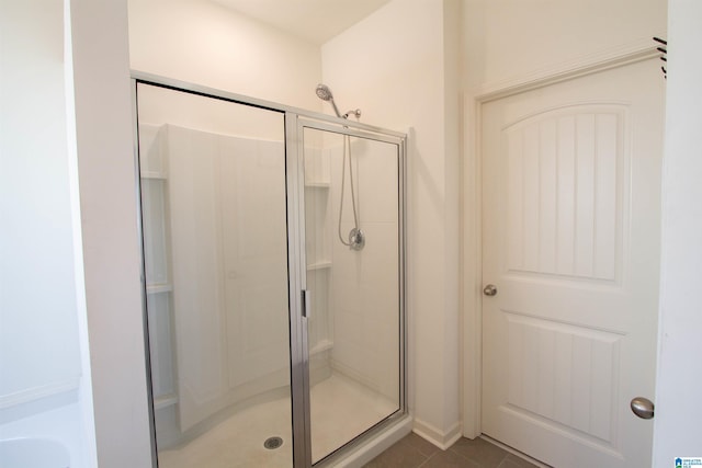 bathroom featuring tile patterned flooring and a shower with shower door