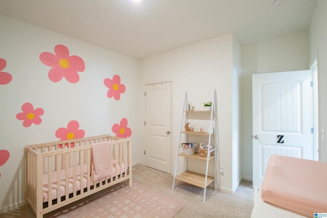 carpeted bedroom featuring a nursery area