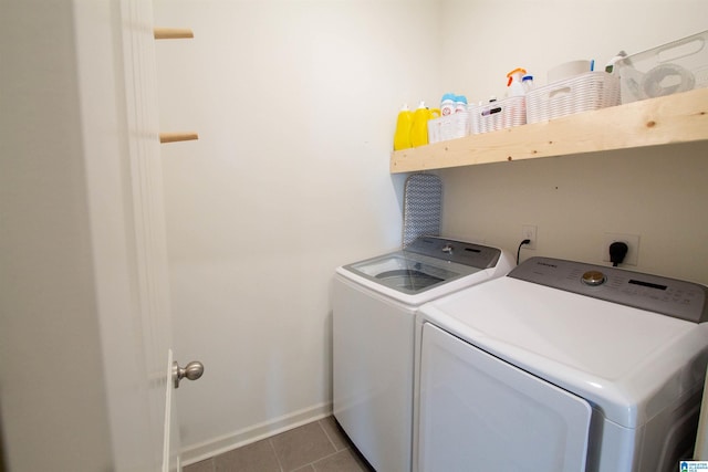 washroom featuring independent washer and dryer and dark tile patterned floors