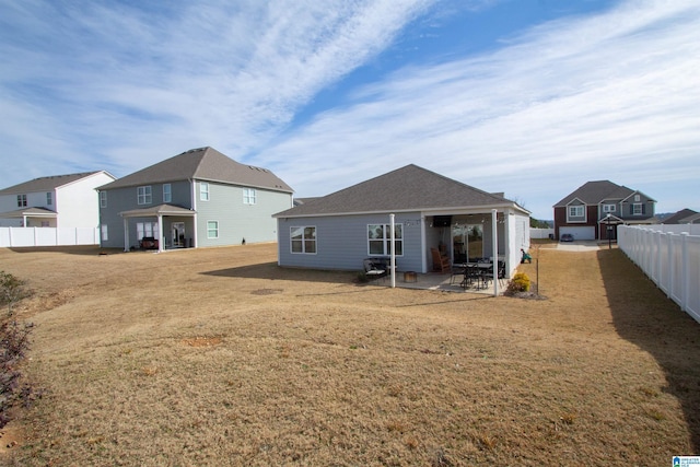 rear view of property featuring a patio area and a lawn