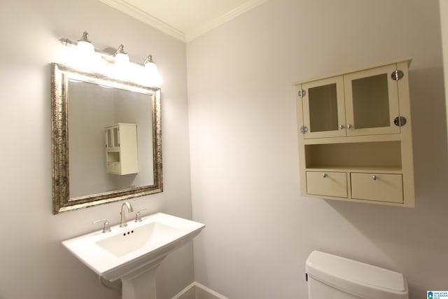 bathroom featuring toilet, sink, and crown molding