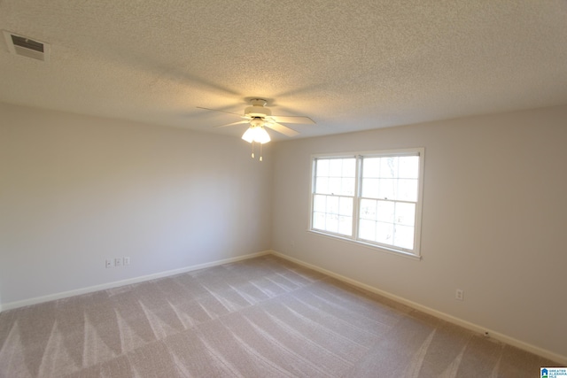 carpeted empty room featuring ceiling fan and a textured ceiling