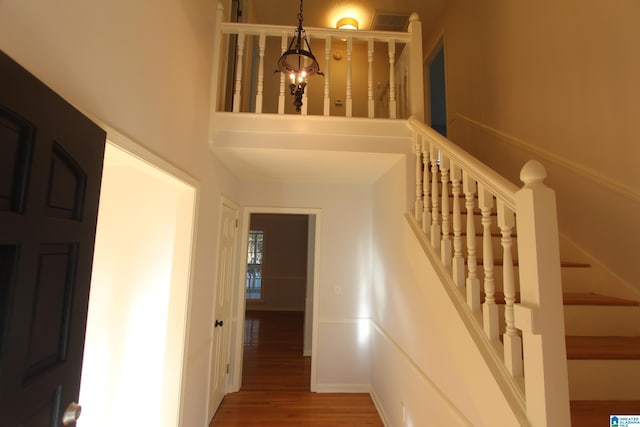 stairs with a chandelier and hardwood / wood-style floors