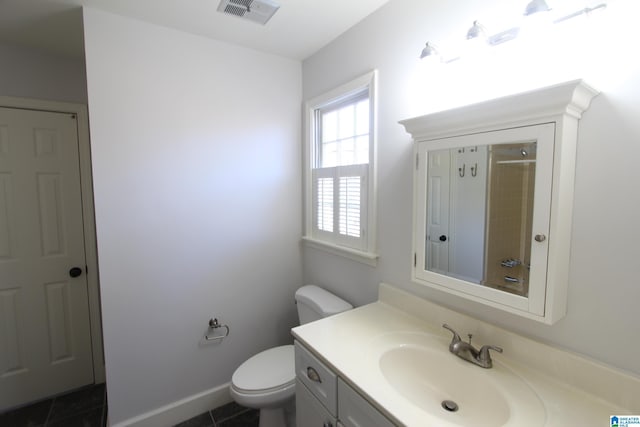 bathroom featuring toilet, vanity, and tile patterned flooring