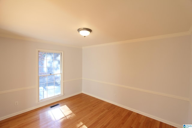 spare room featuring wood-type flooring and ornamental molding