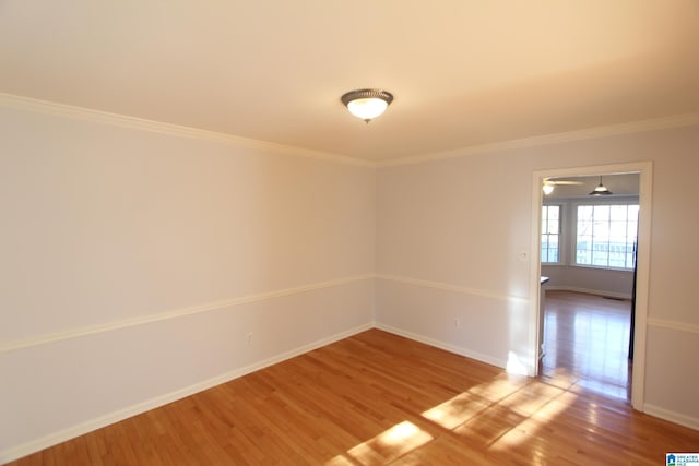 empty room with hardwood / wood-style floors and ornamental molding